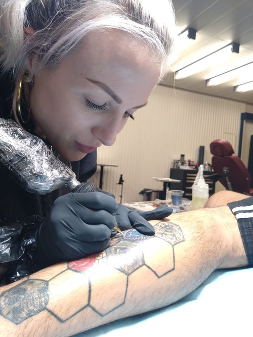 All Aboard Jenna Kerr tattooing her signature bejeweled style on a client at Squid Ink on Virgin Voyages.