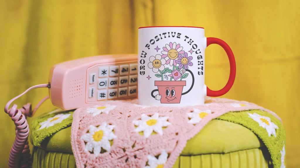 "Grow Positive Thoughts" Mug sits next to pink phone