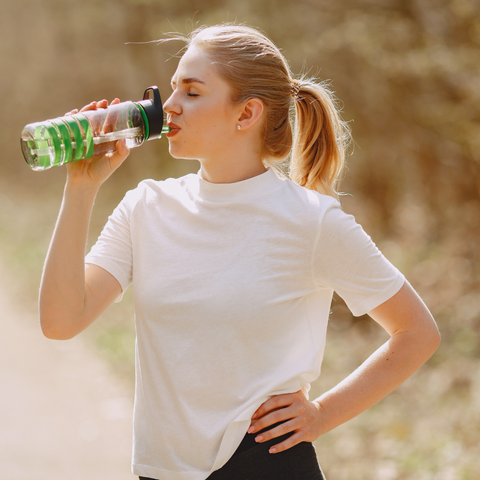 woman drinking from water bottle