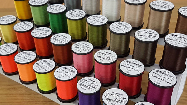 Picture of various Semperfli Classic Waxed Thread arrayed on a multi-tiered stand.