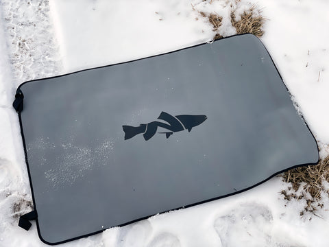 Image showcasing the unrolled Neoprene Wader Changing Mat from NIRVANA On The Fly rolled out in the snow showcasing the mat.