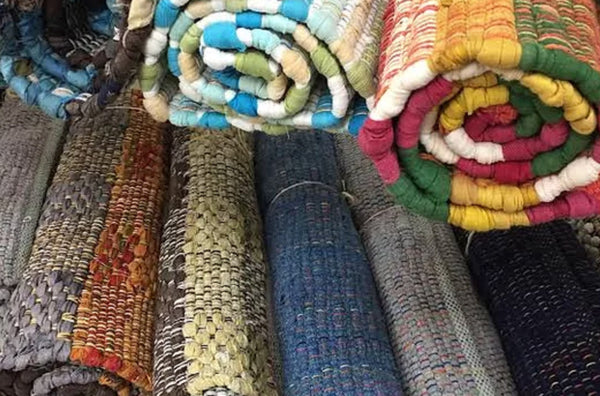 stacks of rolled up rugs in various colours