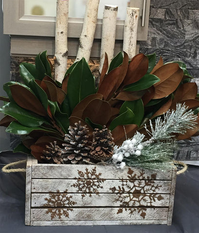 decorated apple crate with snowflakes and various botanical items inside