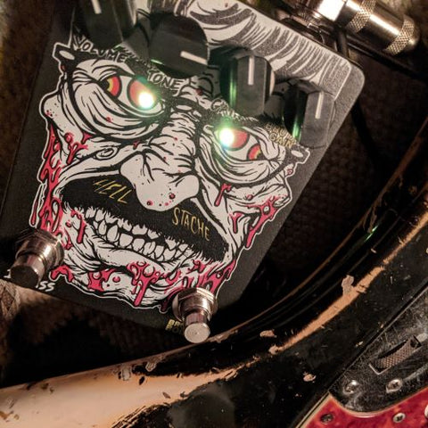 Square shaped effects pedal with 4 knobs and two footswitches. The artwork depicts a demonic cartoon version of Kurt Ballou. His eyes are the l.e.d. lights.