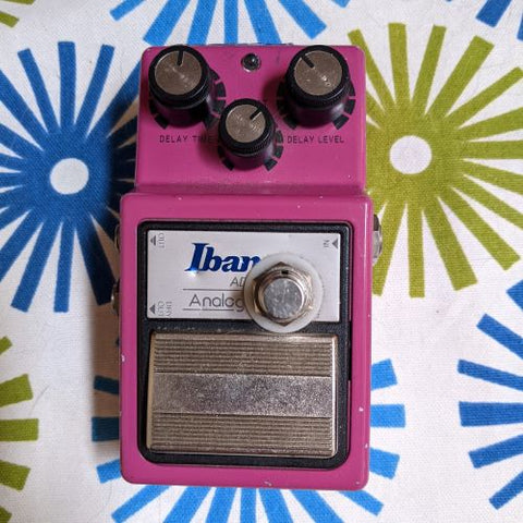 pink rectangular effects pedal. 3 knobs and silver footswitch.