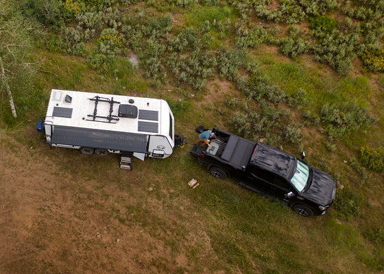 Un camion remorque un camping-car dans une région éloignée.