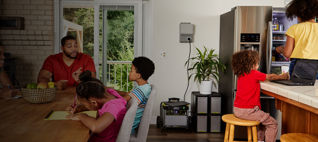 Family gathered in the kitchen and dining room with a Goal Zero Yeti Portable Power Station connected to the Home Integration Kit and four Yeti Expansion Tanks (Home Backup System)