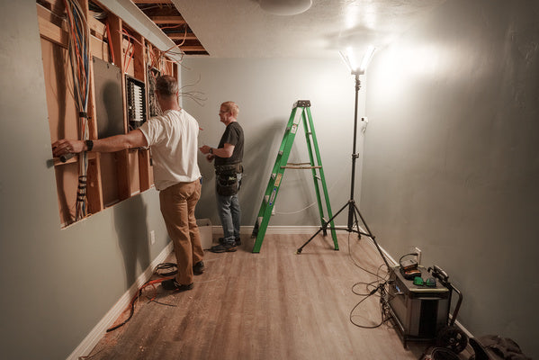 Le puits de lumière fournit de la lumière pendant que les hommes effectuent des travaux électriques dans un sous-sol