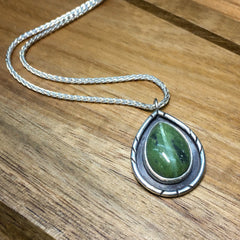 A customized Estelle Geo pendant necklace using a green Opal teardrop center stone