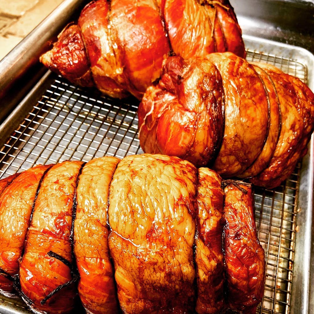A picture showing the golden color of three maple glazed hams after they've been cooked.