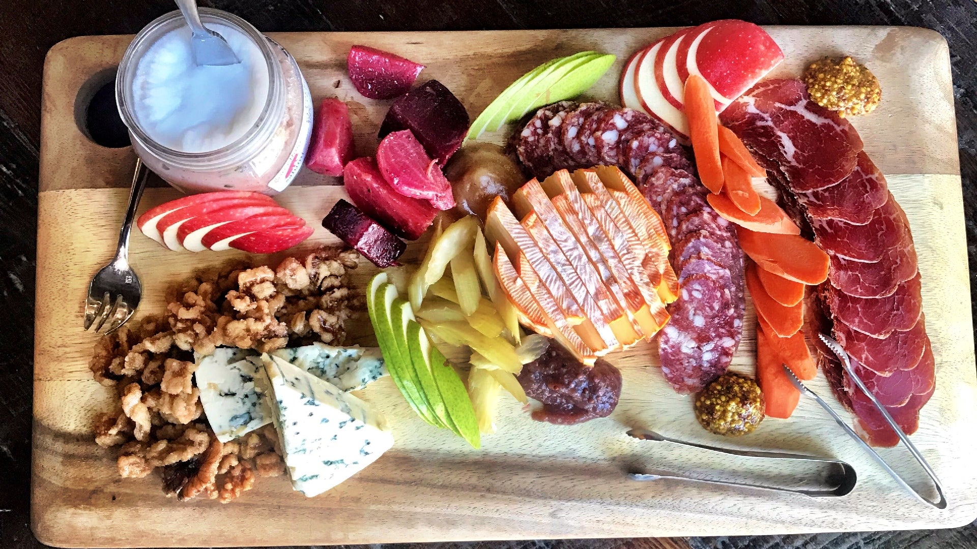 il porcellino salumi's fall harvest charcuterie board with cured meats, cheese, fruits and pickled vegetables.