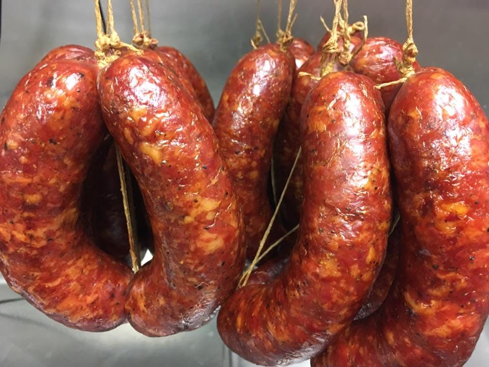 Several smoked kielbasa sausages hanging after being smoked and pictured close up.