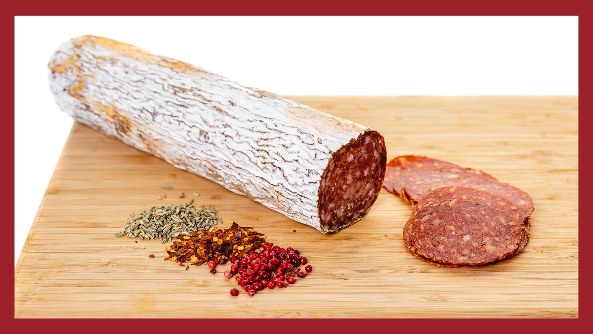 Sopressa on a cutting board with slices and ingredients in the foreground.