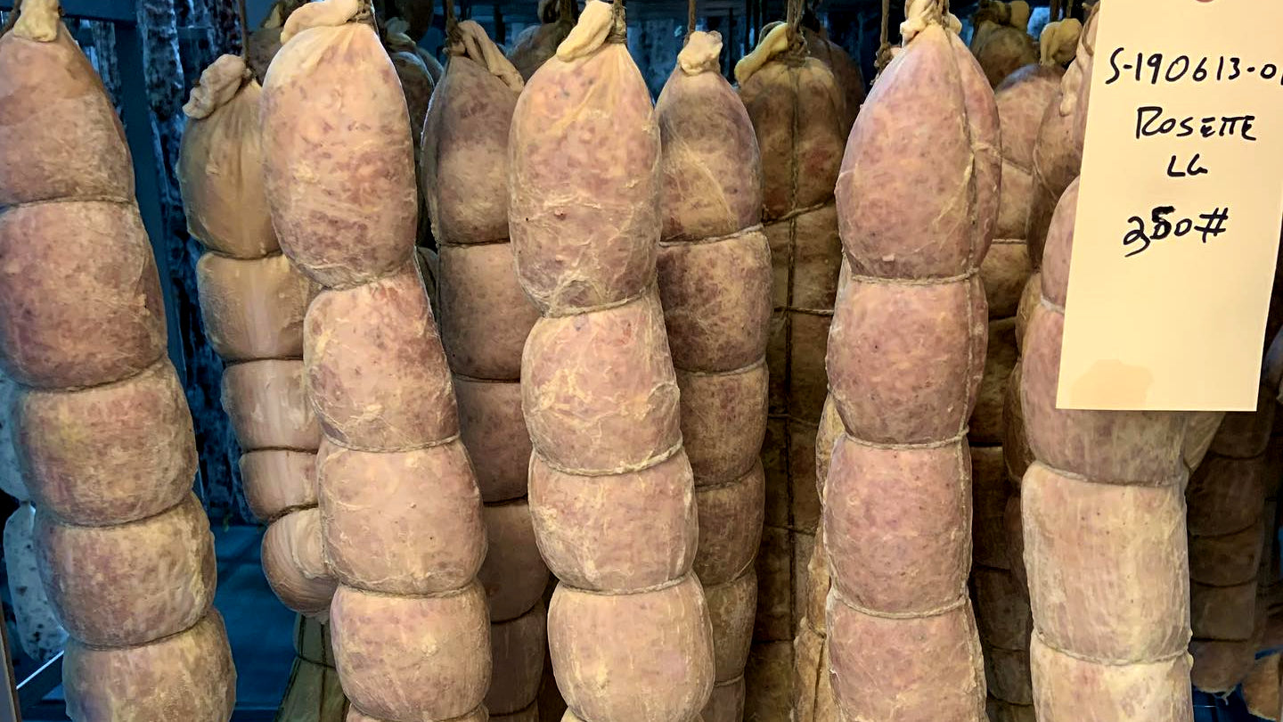 Freshly stuffed salami casings hanging in il porcellino's fermentation room.