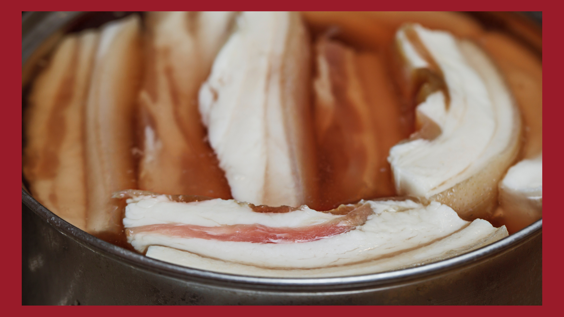 A bunch of pork bellies submerged in a brine to activate the wet curing process.