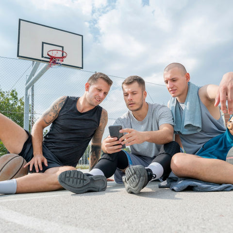 Des passionnés collectionneurs de cartes NBA échangent sur un terrain de basketball