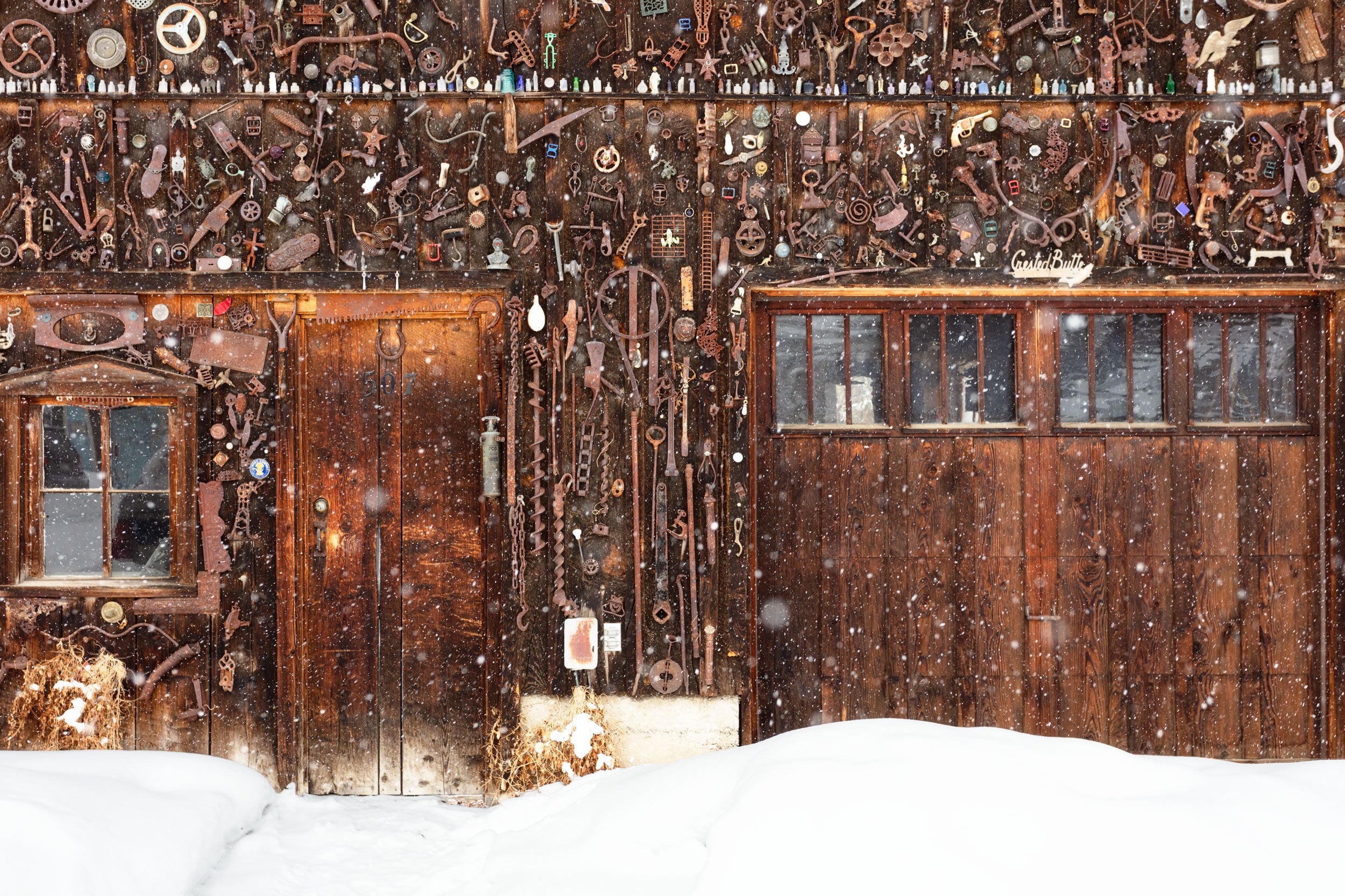 A Lars Gesing Fine Art Nature photograph of a quaint old shed during a snowstorm in the town of Crested Butte, Colorado, one of the best and most popular places to ski and visit in Colorado and one of the best mountain towns in the American West to buy a vacation home.