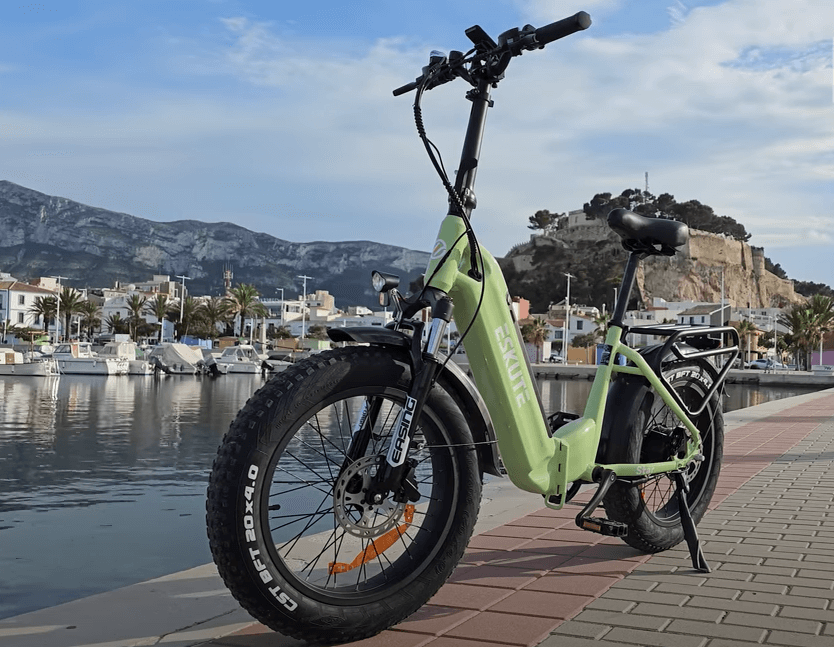 A folding electric bicycle is parked by the lake