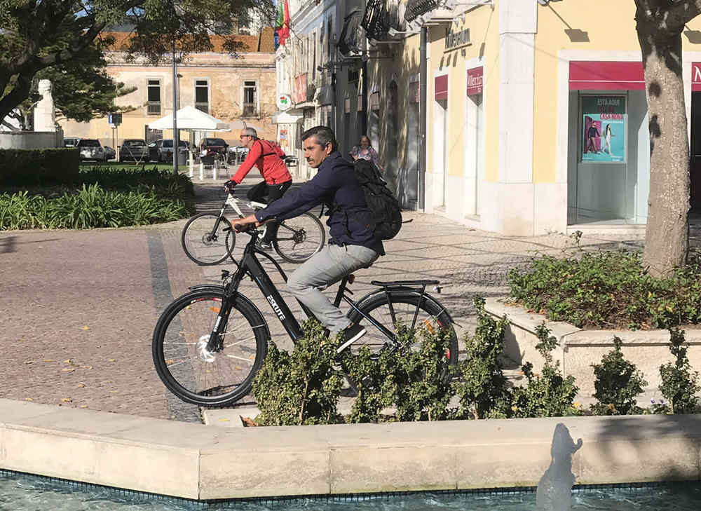 A man rides an electric bicycle and waits for traffic