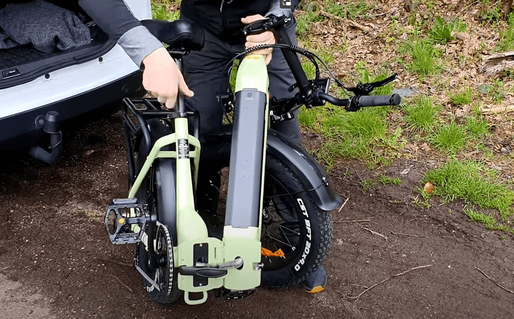 A man unpacks his folding electric bike outdoors