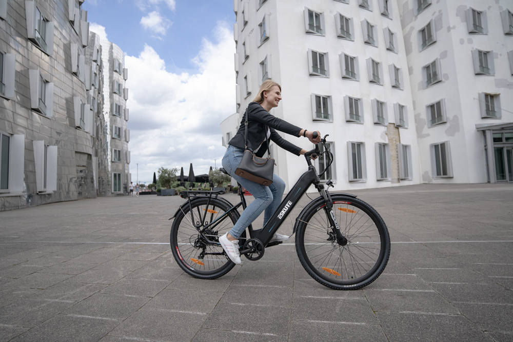 A woman rides a comfortable hybrid commuter e-bike to work