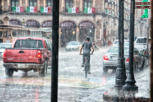 A woman safely riding her electric bike in the rain