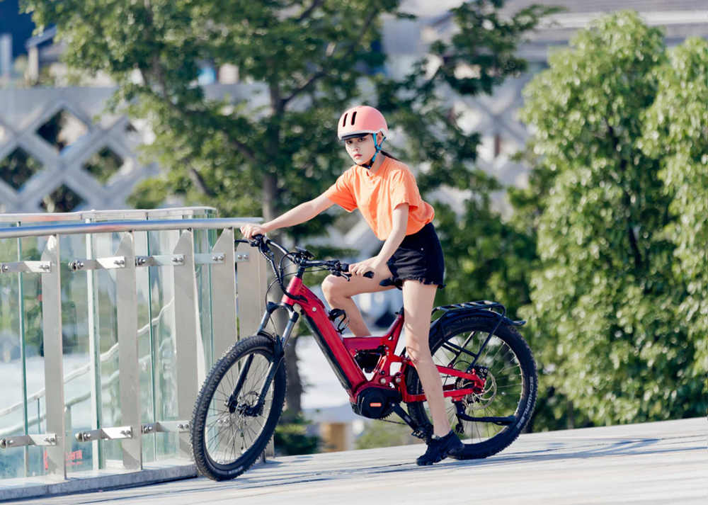 a girl with helmet rides her full suspension e-bike