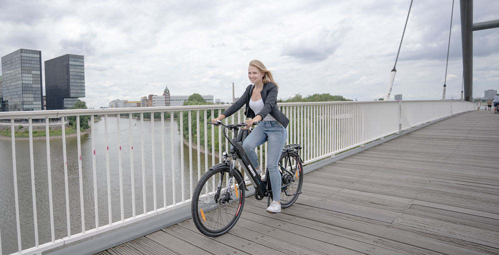 a lady rides an e-bike on the bridge