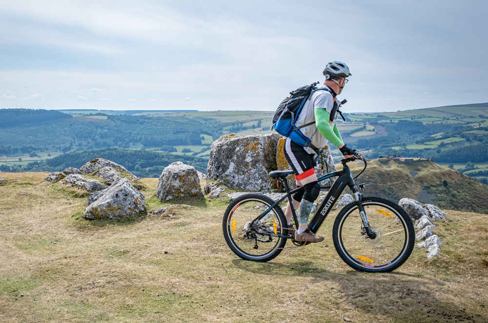 a man is climbing the mountain by his mid drive e-bike