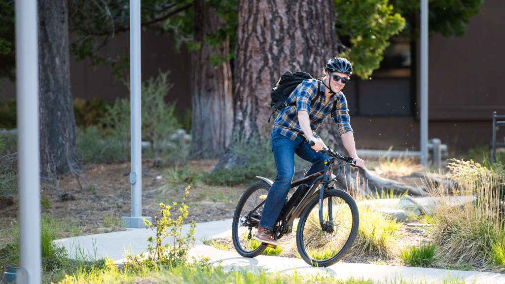 a man with backpack is riding a 350w electric bike