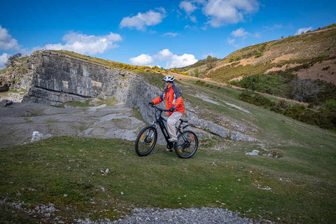 a man with helmet is riding netuno ebike uphill