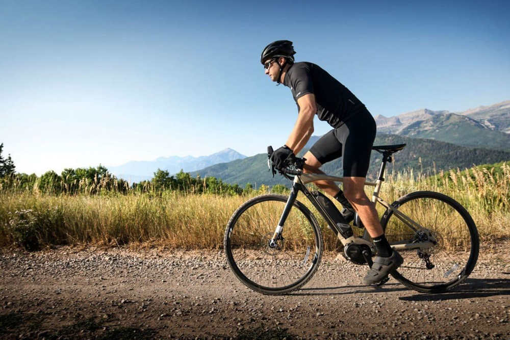 a man with helmet rides a sleek and modern-looking road e-bike