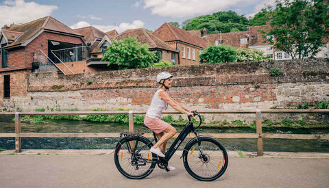 a woman rides Polluno Electric City Bike on the road