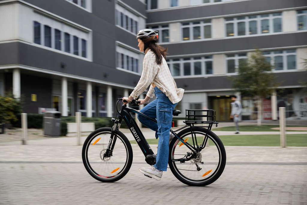 a young lady rides the e-bike with rear rack basket