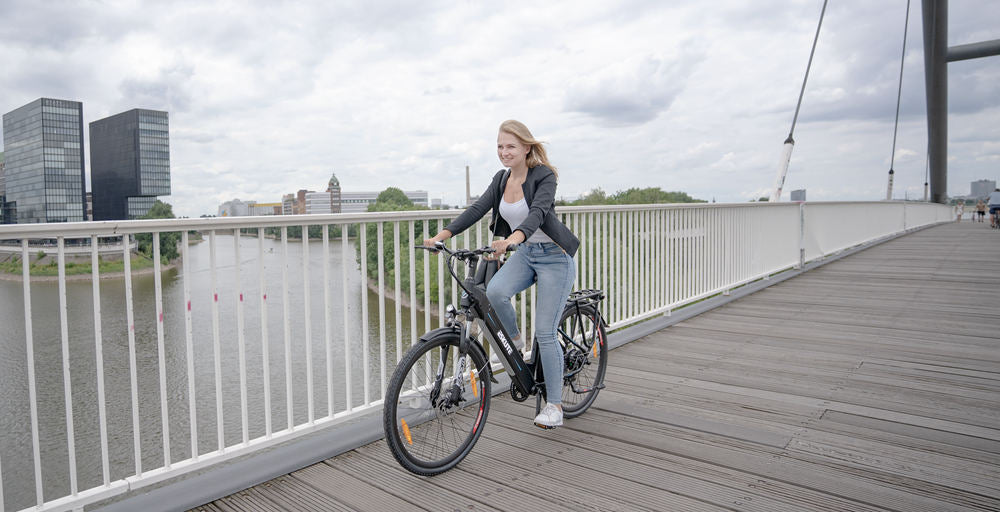 a lady rides an Step-Through e Bike on the bridge