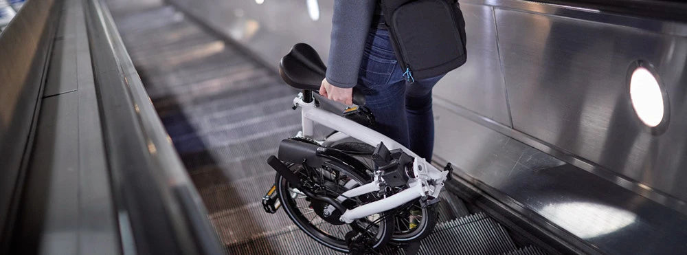 a man goes down on the elevator with folding ebike