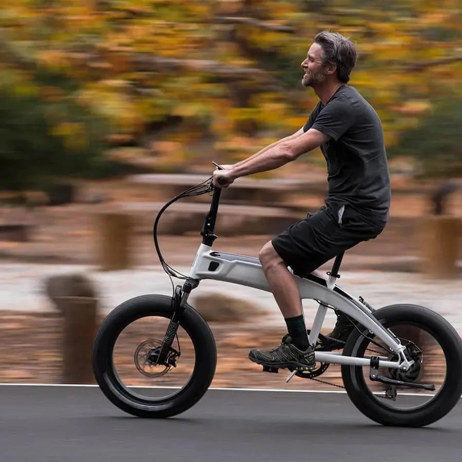 a man is riding an ebike with small tyres on the road
