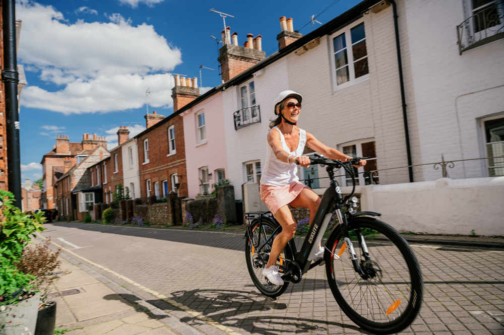 a woman riding ebike on the road with smile