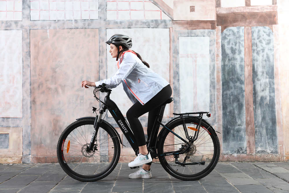 a woman with helmet sits on the ebike