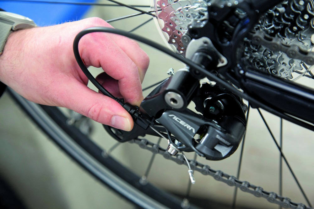 bicycle repairer is fixing the bike gear slipping issues