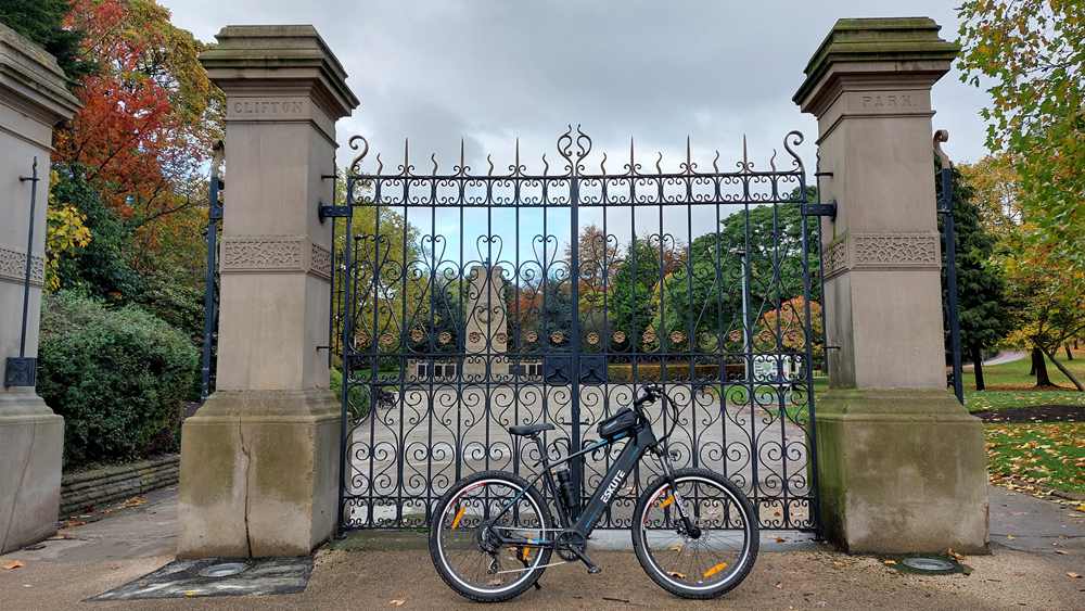 the e-bike is parked outside the gate of the yard