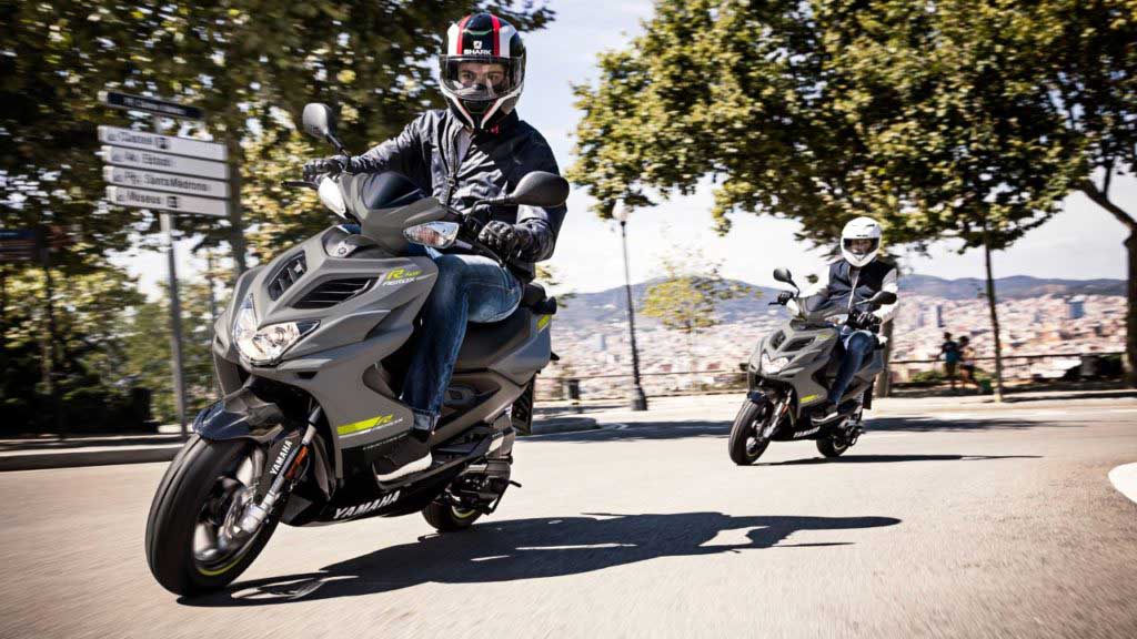 two people ride motorcycles on the road