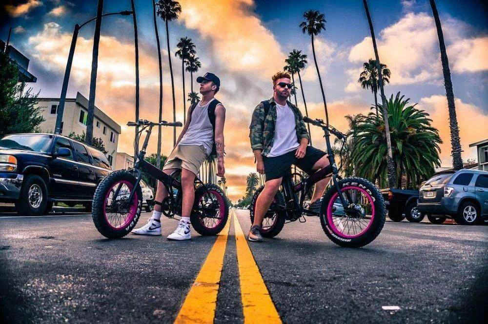 two young men sit on their fat ebikes on the road