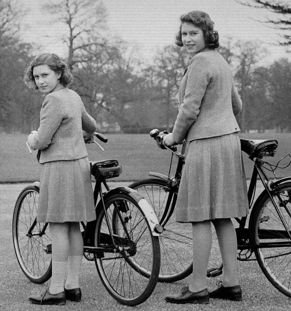 young Elizabeth pushing her bike with her sister