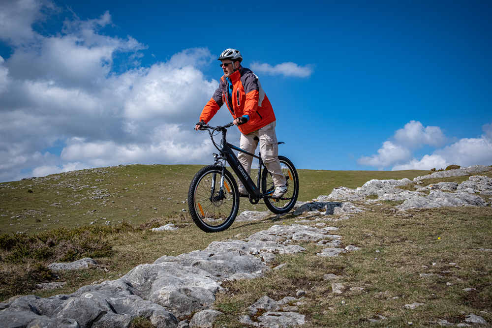 a man with helmet is riding netuno crossbar ebike on the mountain top