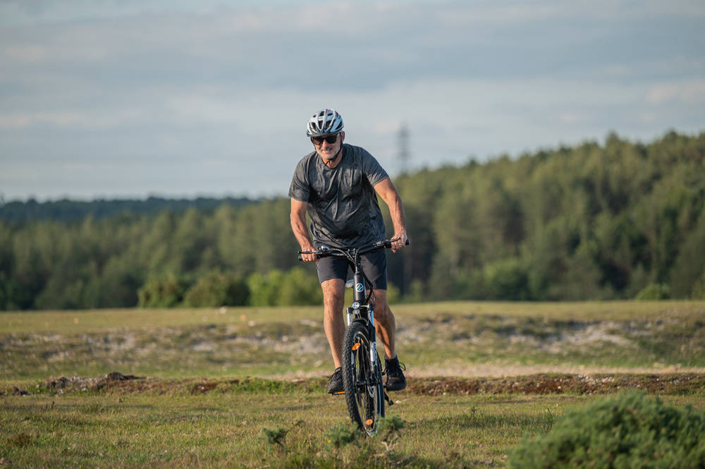 a man with helmet is riding netuno ebike in the wild