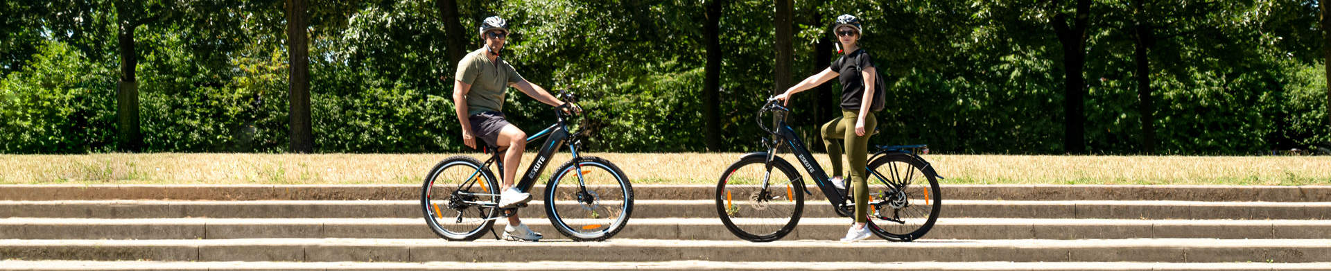 A man and a woman are riding electric bikes at the lakeside