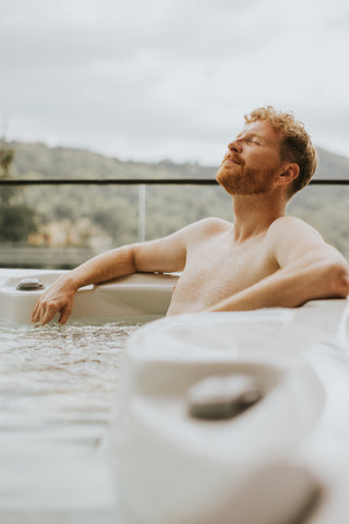 healthy man enjoys hot tub in winter