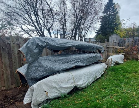 store canoes on a rack covered with a tarp