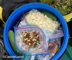 Open bag of GORP in the top of a blue canoe barrel